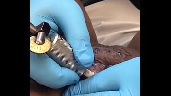 Мастер делает татуировку на лобке негритянке